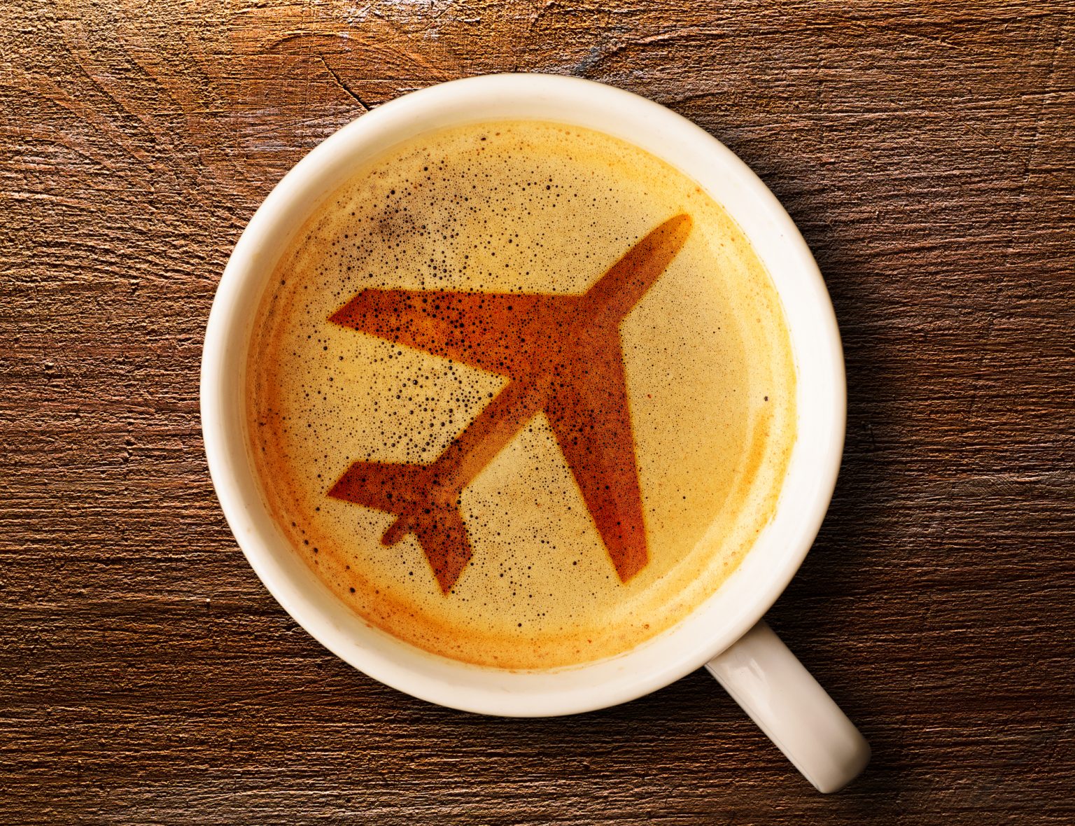 cup of coffee with an airplane indicating someone wants to understand how to eat healthy while traveling