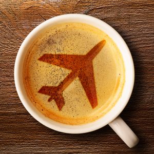 cup of coffee with an airplane indicating someone wants to understand how to eat healthy while traveling