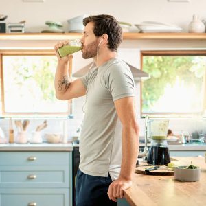 Athletic man drinking a smoothie, fueling for an upcoming workout