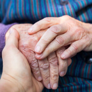 adult daughter comforting elderly mother